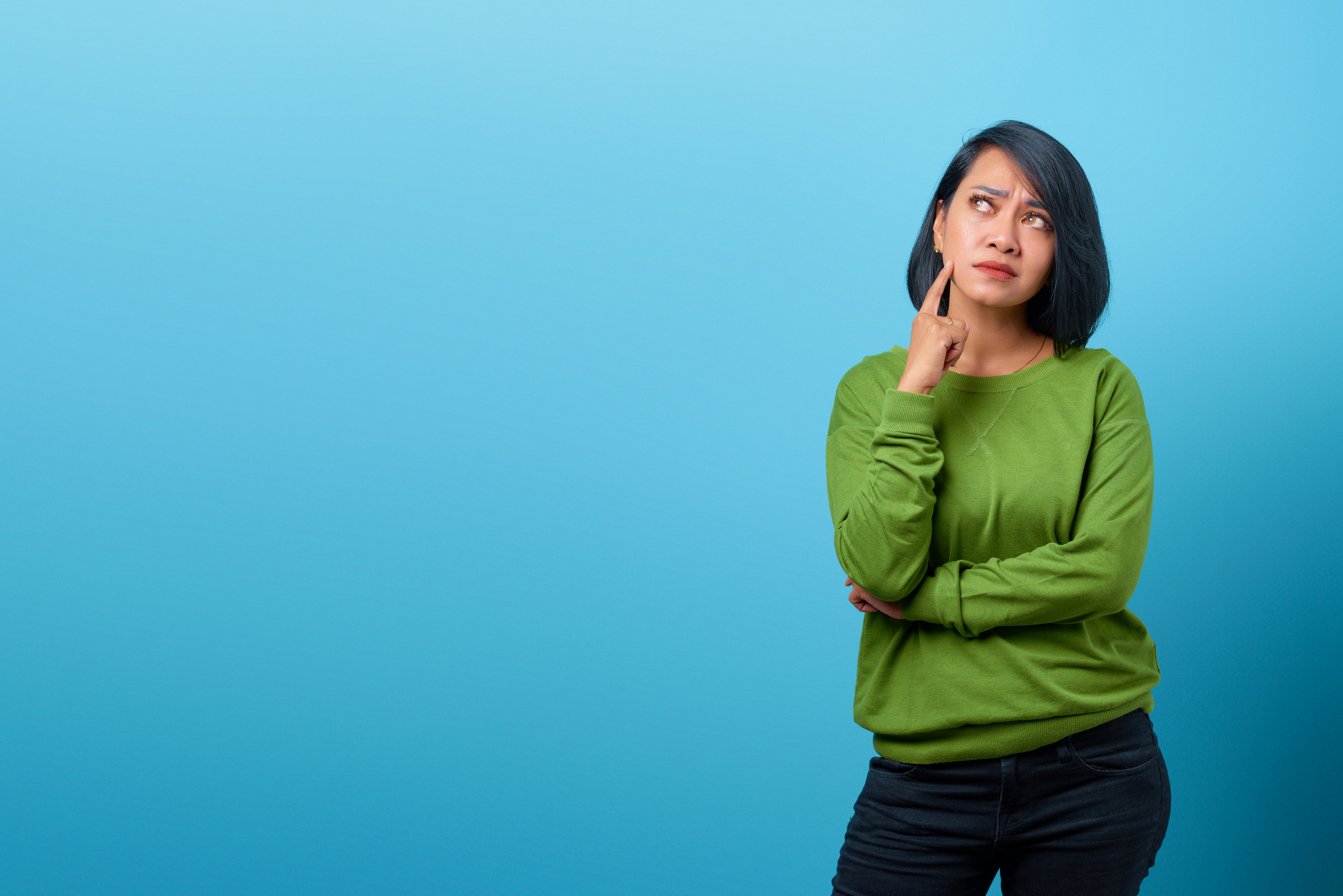 Attractive Asian Woman Thinking and Looking up Empty Space on Bl